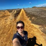 ハワイでの自撮り。まっすぐ続いた道と青空が背景。