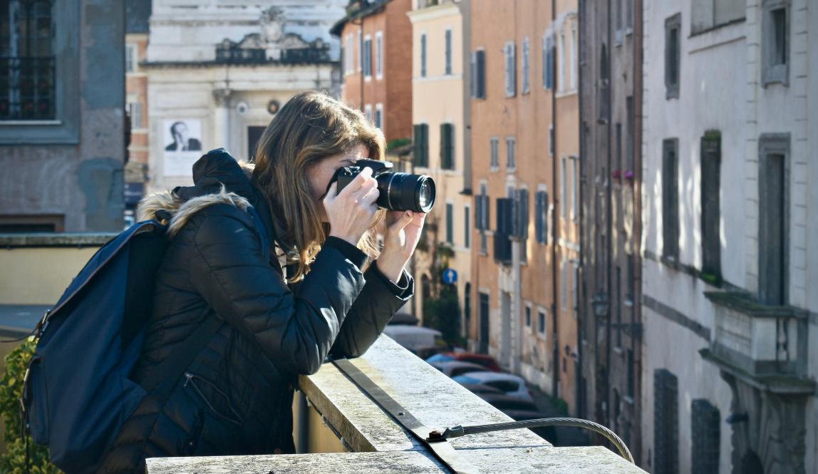 a student taking a photo on a rooftop in Rome