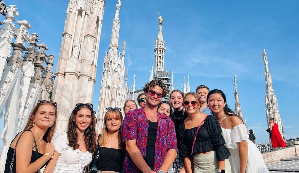 A group of students smile outside Il Duomo in Milan, Italy.