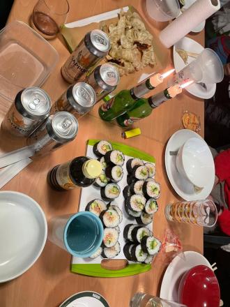 友人たちとのパーティー中、巻き寿司を食べる写真