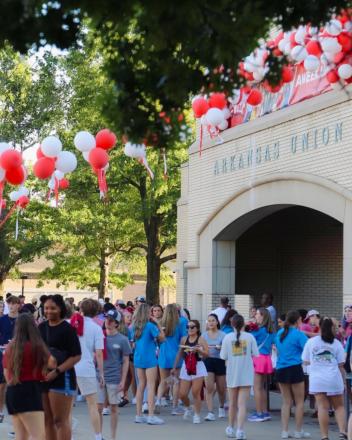アメリカ、アーカンソー大学のA-Weekの様子。右手奥にArkansas Unionと書かれた白い建物があり、紅白の風船で飾られている。中央にはたくさんの大学生。