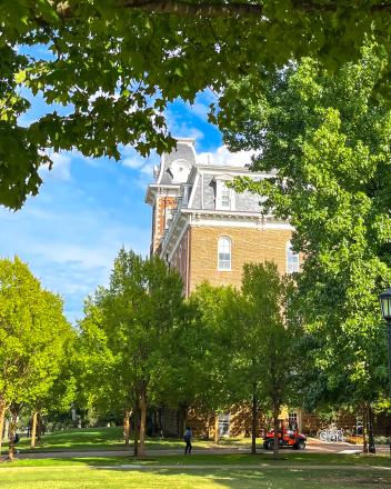 アメリカ、アーカンソー大学の建物。緑豊かなキャンパスから顔をのぞかせるレンガ造りの校舎。