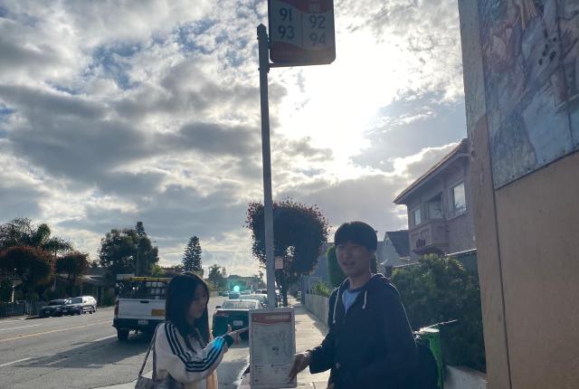 Two students at a bus stop in Long Beach.