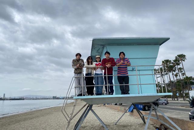 Five students standing at a lifeguard tower on a Long Beach beach.