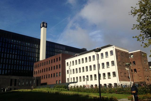 A large brick building sits on the Universiteit van Amsterdam's campus.