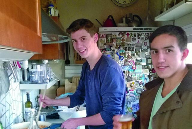 Two students cook in a small, rustic kitchen in Milan.