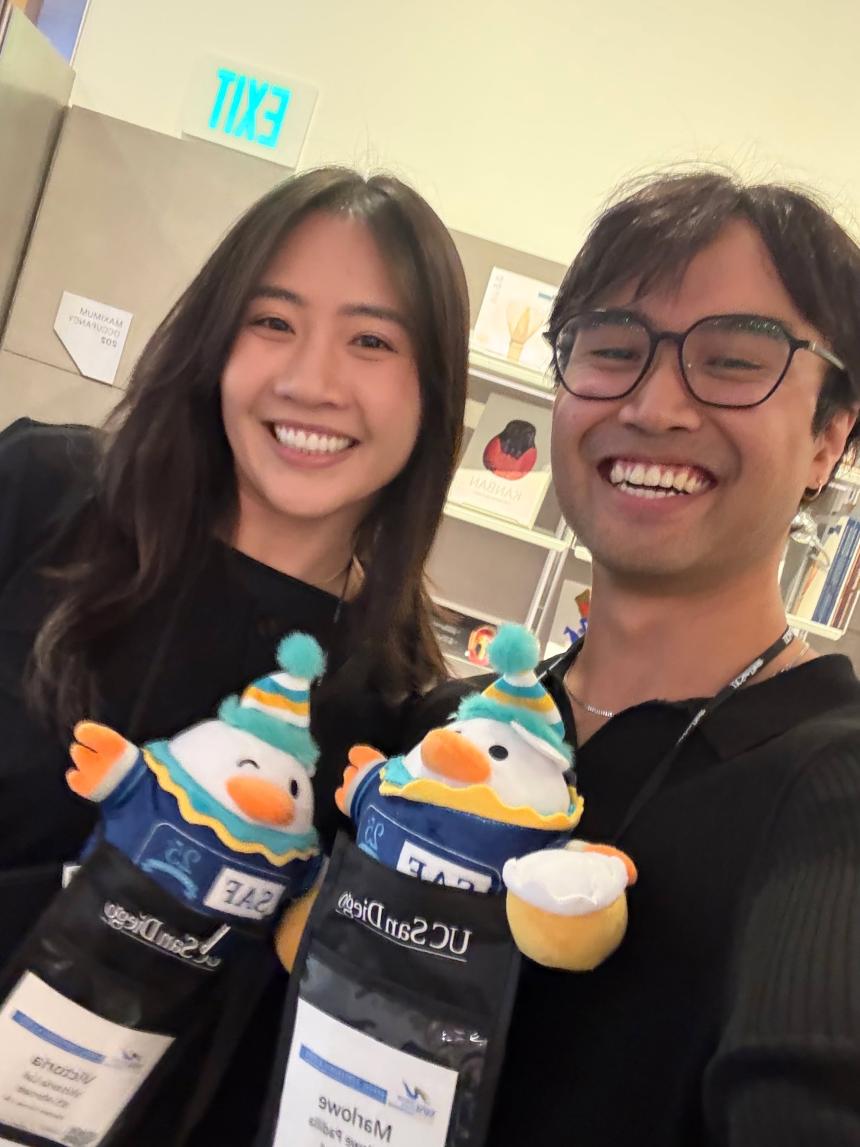 SAF staff Victoria Lai and Marlowe Padilla posing with 25th anniversary SAFFY dolls at NAFSA 2025
