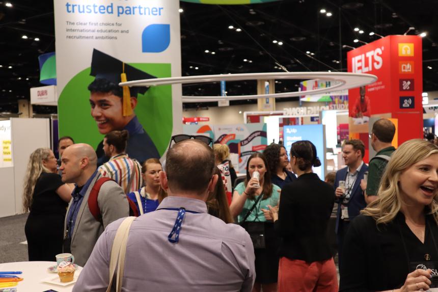 Various people chatting in front of booths inside the NAFSA 2026 convention.