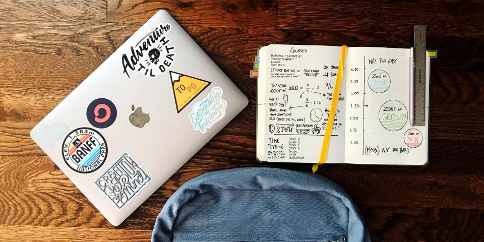 student laptop backpack and planner laid out on table