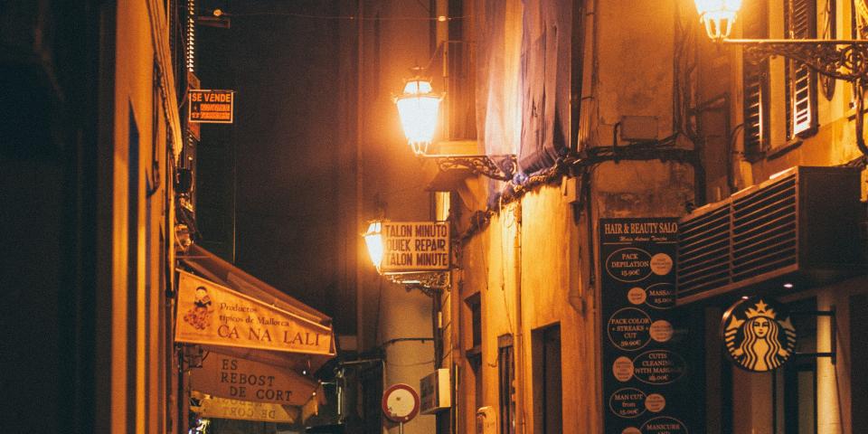 an alley in spain at night lit with streetlamps