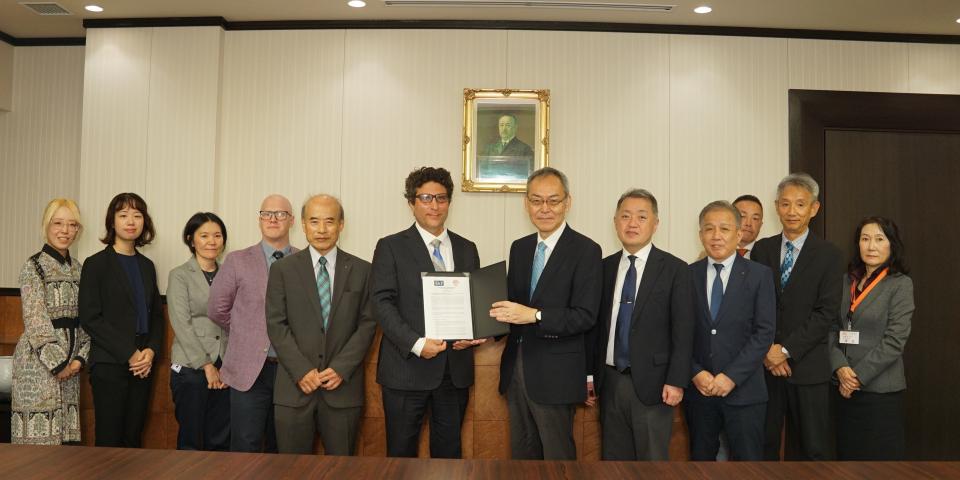 A group of SAF and Takushoky University offiicals in Japan stand together for a group photo